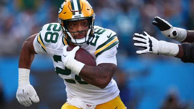 This image is about AJ Dillon, Green Bay Packers running back, carrying the football .
