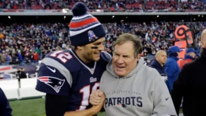 This image is about Tom Brady and Bill Belichick share a celebratory moment on the field.